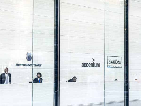 Lobby view with signs for offices of National Hockey League, Accenture, Skadden, Arps, Slate,