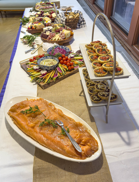 Charcuterie boards, savory tarts and plate of salmon on long table