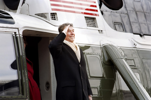 Former U.S. President Ronald Reagan saluting as he departs aboard helicopter as he leaves U.S.