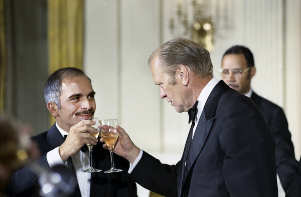 U.S. President Gerald R. Ford and King Hussein of Jordan raising their glasses at stag dinner held