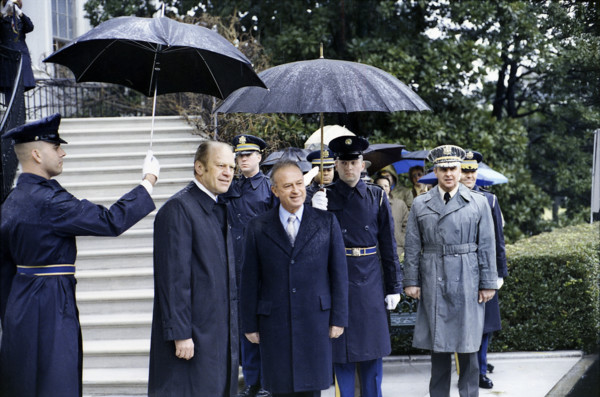 U.S. military guards holding umbrellas over U.S. President Gerald R. Ford and Prime Minister