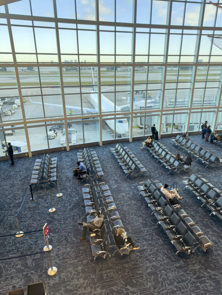 High angle view of travelers relaxing in departure lounge, Delta Airlines, Fort