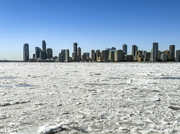 View of Jersey City, New Jersey, USA skyline across frozen Hudson River