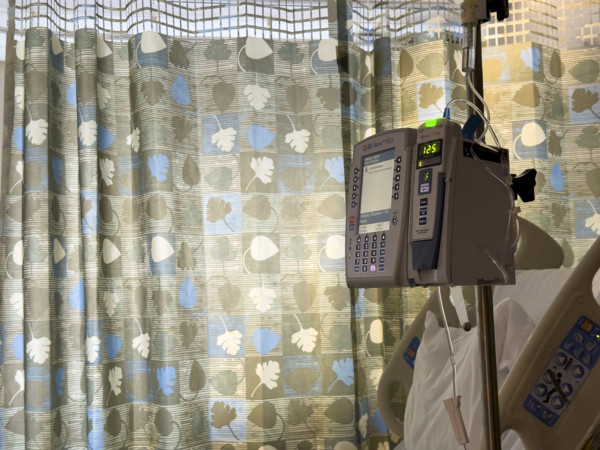 Empty hospital bed in patient room with medical equipment