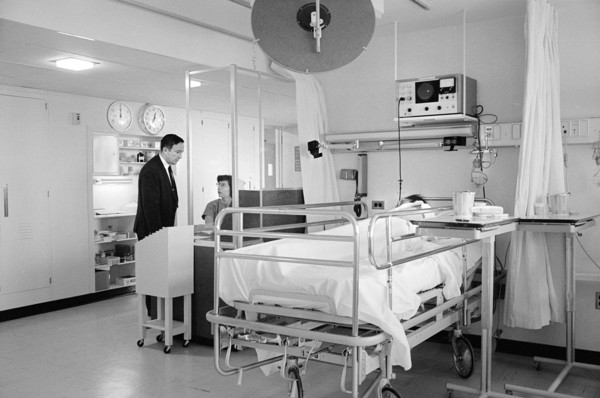 Patient in bed and staff in hospital room, Morris Cafritz Memorial Hospital, Washington, D.C., USA,