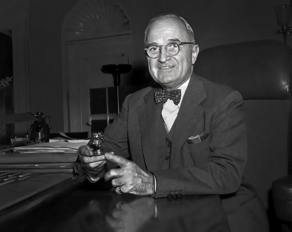 U.S. President Harry S. Truman sitting at his desk with paperweight, a gift to him from a 4-H