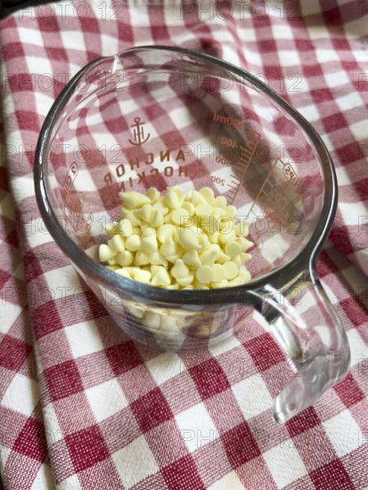 White chocolate chips in glass measuring cup