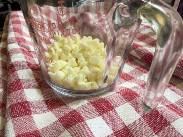 White chocolate chips in glass measuring cup