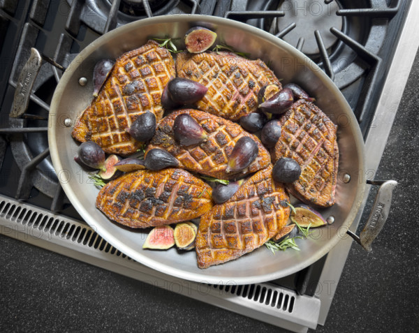 High angle view of pan-seared duck breasts with figs and rosemary