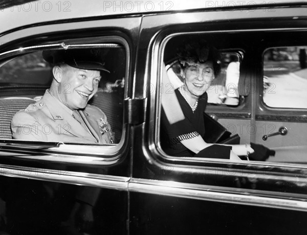 U.S. General Dwight D. Eisenhower and his wife Mamie Eisenhower smiling in back of limousine after