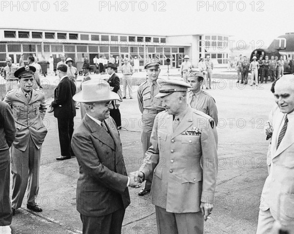 U.S. President Harry S. Truman (left) shaking hands with U.S. General Dwight Eisenhower (right),