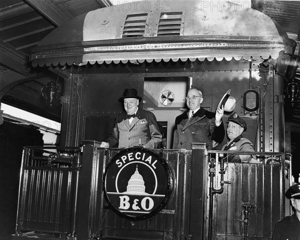 U.S. President Harry S. Truman (right) waving his hat standing to right of former British Prime