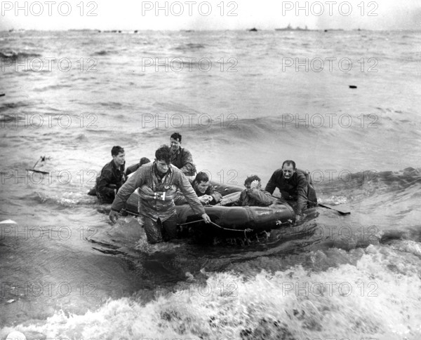 Survivors of sunken LCVP off coast come safely ashore in rubber life raft, Omaha beach, Cherbourg