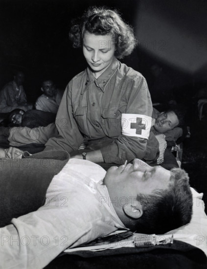 Lt. Elizabeth Babarsik, Canton, Ohio, checking temperature of Private John L. Bennett, Reading,