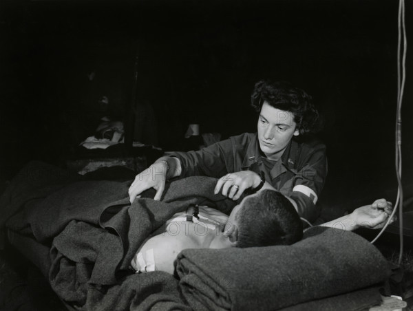 Lt. Ann Howe, Boston, Massachusetts, a U.S. Army nurse, attending a G.I. with lung wound in an