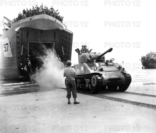 Sherman tanks, manned by French armored troops, rolling out from landing ship ramp onto Utah beach,