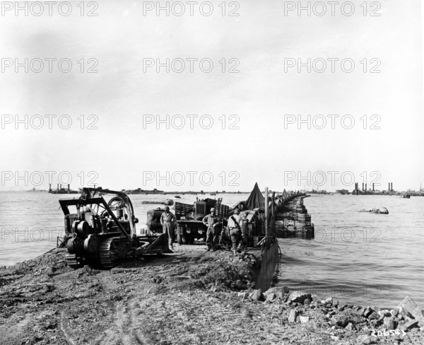 American soldiers expediting transportation of materiel at shore end of one of two projects,