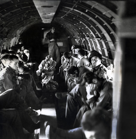 Nurse with wounded American soldiers on C-47 airplane crossing English Channel from Normandy,