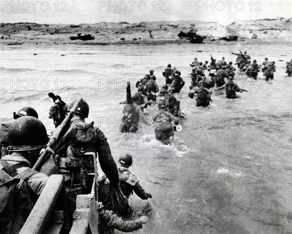 American troops plunge into surf and wade shoreward carrying equipment, Utah Beach, La Madeleine,