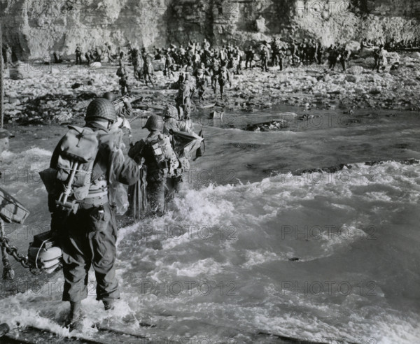 American troops wading through surf before joining additional troops on beachhead, Normandy,
