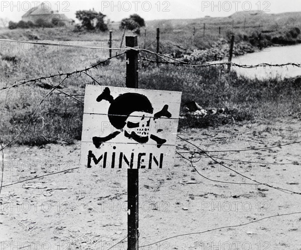 Abandoned German minefield surrounded by barbed wire discovered by advancing U.S. Army troops,