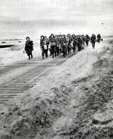 First arrivals of U.S. Women's Army Corps marching from disembarkation pier to transportation and