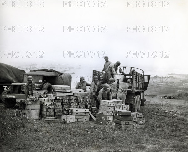 American members of 616th Ordnance Company load ammunition for the famed German 88 gun onto a truck