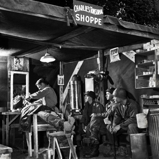 American soldiers wait their turn at Charlie's Tonsorial Shoppe, Normandy, France, U.S. Army Signal