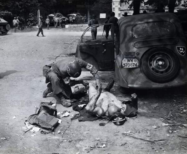 American medic giving first aid to wounded German officer, Chartres, France, U.S. Army Signal