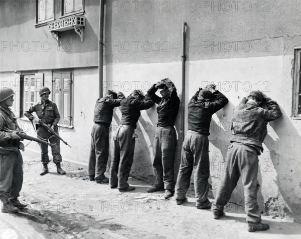Pfc. Herbert Lusk and Sgt. Joseph F. Mannix guard SS troops captured by units of U.S. 1st Infantry