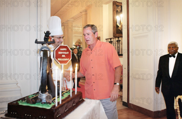 U.S. President George W. Bush being presented with birthday cake at his birthday party, White House
