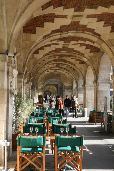 France, Paris 4e, le marais, place des vosges, appareil de briques et pierre, arcades, chaises empilees, tables terrasse de restaurant,