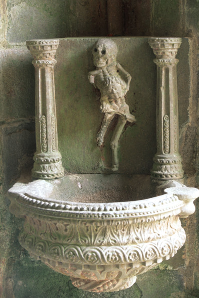 France, Bretagne, Finistere nord, circuit des enclos paroissiaux, enclos paroissial de La martyre, figure de l'ankou au dessus du benitier, symbole de mort violente,