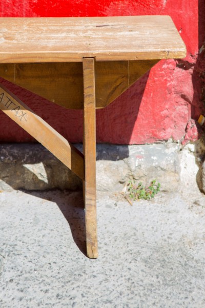Banc en bois devant un mur rouge