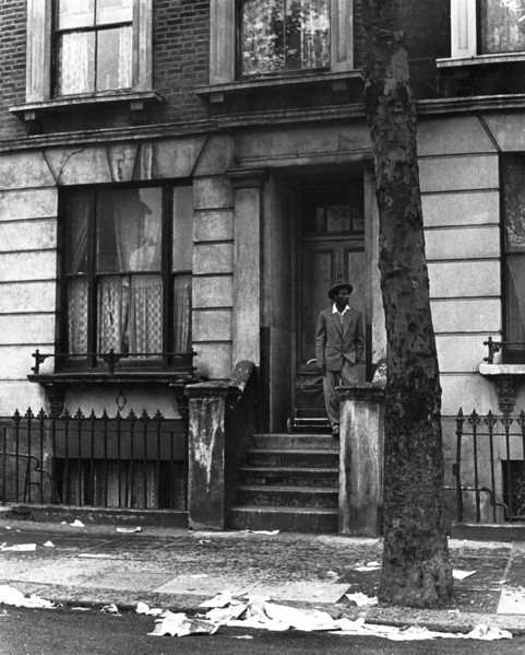 A man standing outside a house in Westbourne Grove, possibly in Kensington, London, 1950s. Creator: Henry Grant.
