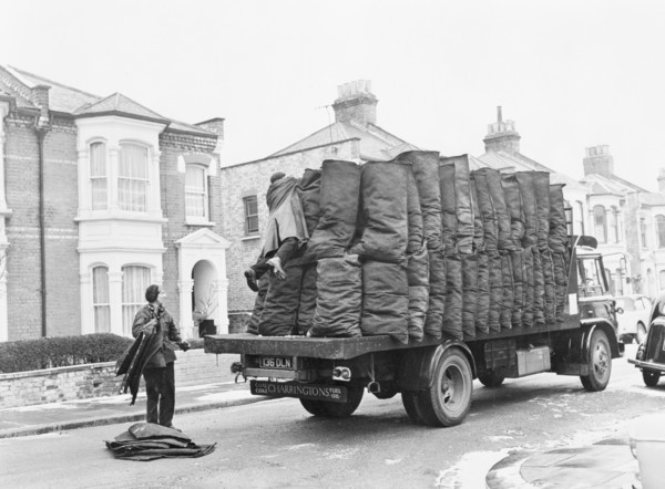 Charringtons delivering sacks of coal down a residential street. Artist: Unknown