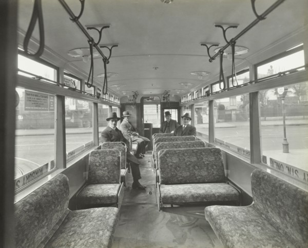 Men in hats and coats in the interior of an electric tram, London, 1933. Artist: Unknown.