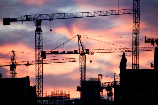A building site at sunset with cranes silhouetted against a red sky, 2007