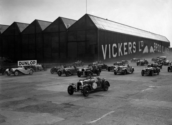 Cars racing at the MCC Members Meeting, Brooklands, 10 September 1938. Artist: Bill Brunell.