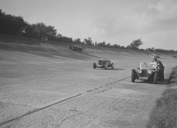 Cars racing on Byfleet Banking during the BRDC 500 Mile Race, Brooklands, 3 October 1931. Artist: Bill Brunell.