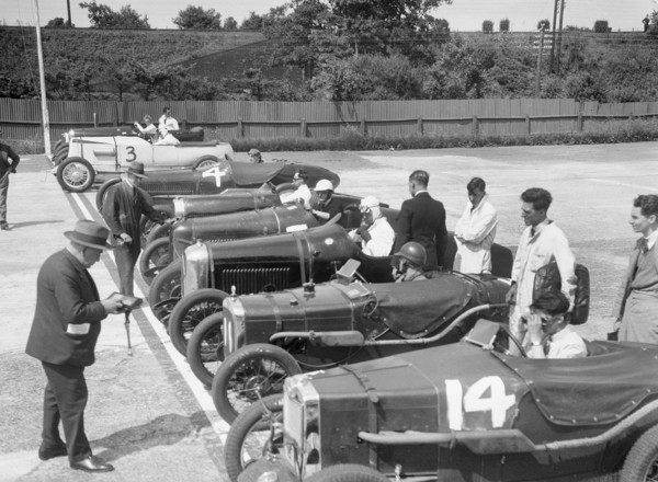 Cars on the start line for a motor race at Brooklands. Artist: Bill Brunell.
