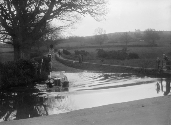 MG Magnette driving through a ford during a motoring trial, 1936. Artist: Bill Brunell.