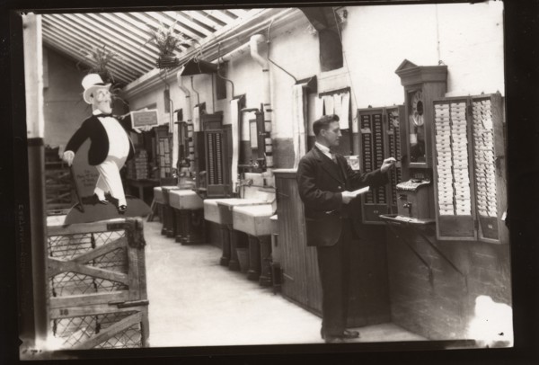 A man uses the clocking in machine, Rowntree factory, Yorkshire, 1929. Artist: Unknown