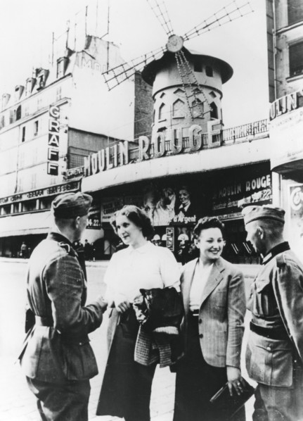 Des soldats allemands discutant avec des Françaises devant le Moulin Rouge, Paris occupé, juin 1940