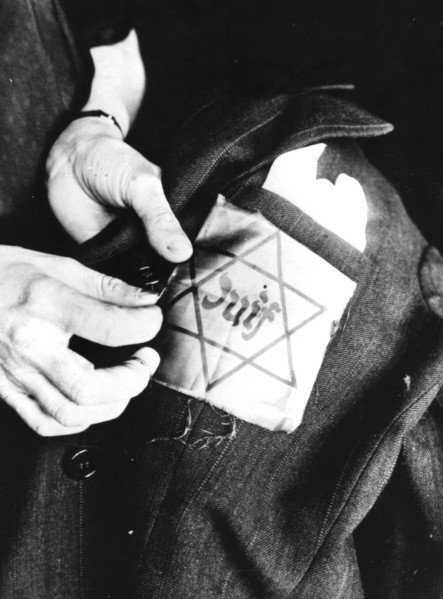 Sewing the yellow star identifying a Jew onto a jacket, German-occupied Paris, 1942. Artist: Unknown