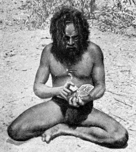 A man from the Warramunga tribe making a stone axe head, Australia, 1922.Artist: Spencer and Gillen