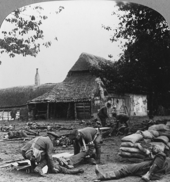 Stretcher bearers caring for wounded at an improvised first aid post, World War I, c1914-c1918.  Artist: Realistic Travels Publishers