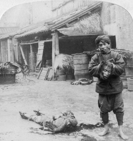 'The grim executioner taking the labled head to exhibit a warning', Canton, China, 1900.  Artist: Underwood & Underwood