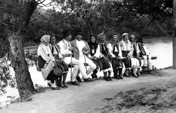 Group of people seated on a bench, Bistrita Valley, Moldavia, north-east Romania, c1920-c1945. Artist: Adolph Chevalier