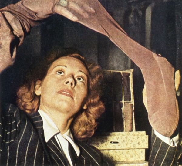 A woman in Paris examines a pair of silk stockings, 1941 Artist: Unknown